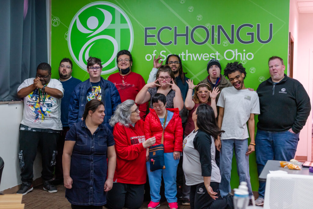 Group photo of EchoingU students and classroom instructors. Laughing, silly faces, funny hand signals, having fun.