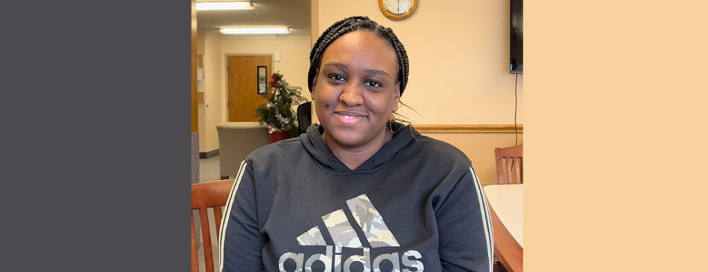 Featured Faces meet Torrianna. She sits smiling wearing a gray adidas sweatshirt