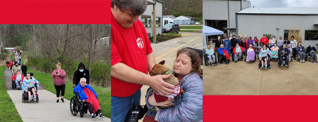 People in wheelchairs and walking to raise money for a worthy cause. Man in red shirt petting a friendly dog that joined in the fun.