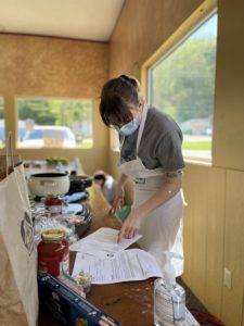 Wearing a classic white apron, an individual at Echoing Hills of Southeast Ohio is preparing a nutritious meal.