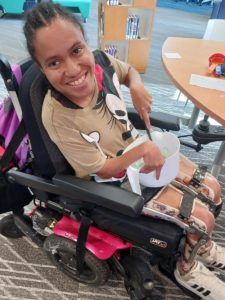 smiling young woman in a wheelchair fixing a meal