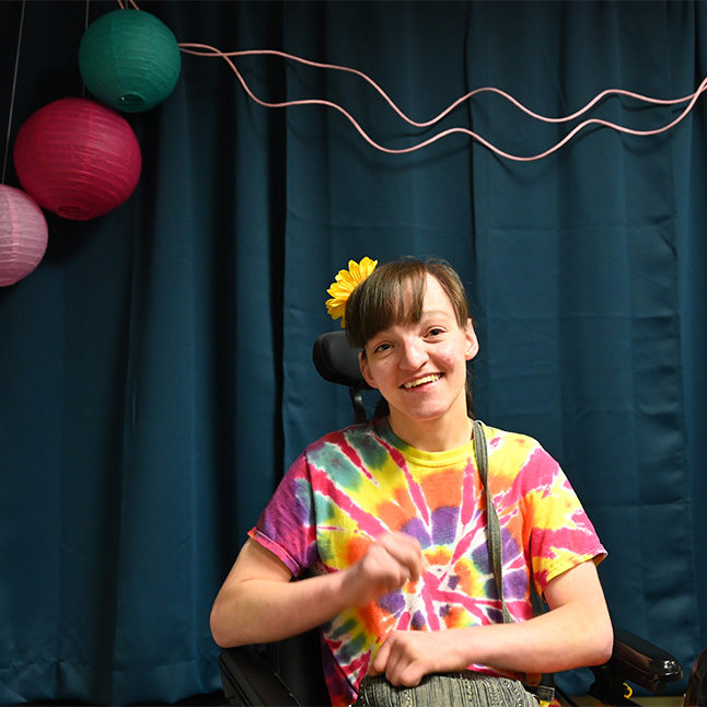 Young woman in tye dye tshirt smiling at a dance at EchoingU.