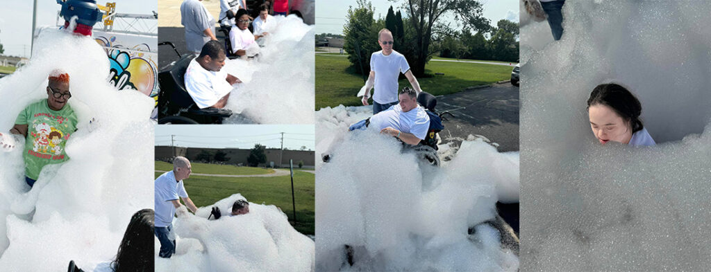 People smiling and laughing as a bubble truck creates an atmosphere of fun and laughter. White bubbles surround people in wheelchairs and those standing. Echoing Hills people enjoy and day of activity and a new experience with the bubble truck.