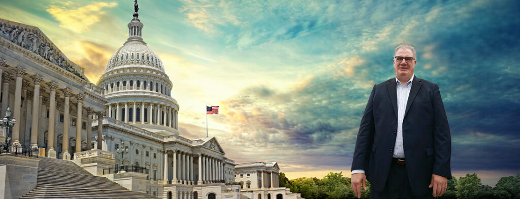 Echoing Hills President and CEO Tim Neville pictured in front of the Capitol Building smiling in a dark suit.