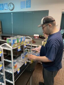 Learning to store food while volunteering at the food pantry.