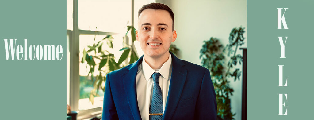 Meet Kyle. Dressed in a deep blue suit and tie, Kyle is smiling. He has short dark hair. Welcome to Echoing Hills.